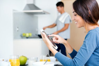 Çift mutfakta kahvaltı hazırlarken ve internet tarama