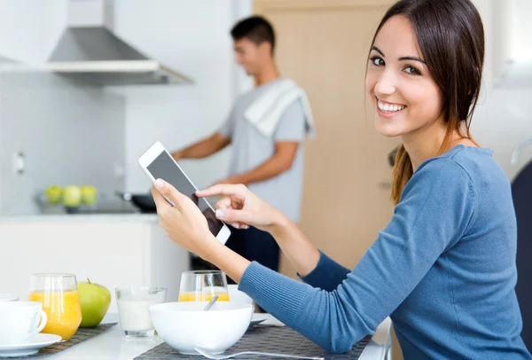 Pareja en la cocina preparando el desayuno y navegar por Internet — Foto de Stock