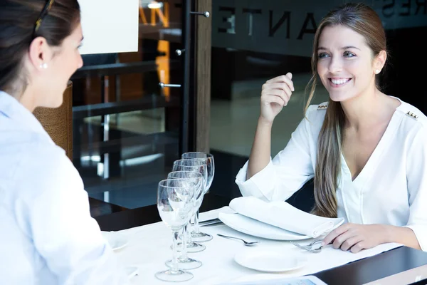 Två leende affärskvinnor äta middag på restaurang — Stockfoto