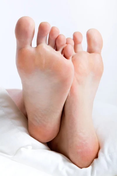 Woman's feet in bed on a Sunday morning — Stock Photo, Image