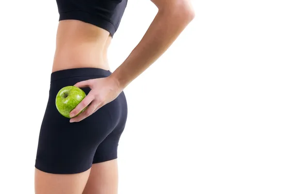 Женщина в спортивной одежде держит яблоко — стоковое фото