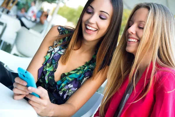 Dos amigos divirtiéndose con teléfonos inteligentes — Foto de Stock