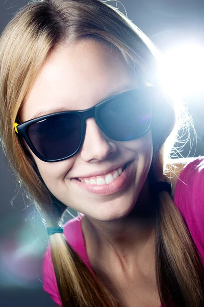 Mujer joven feliz con gafas de sol mirando a la cámara — Foto de Stock