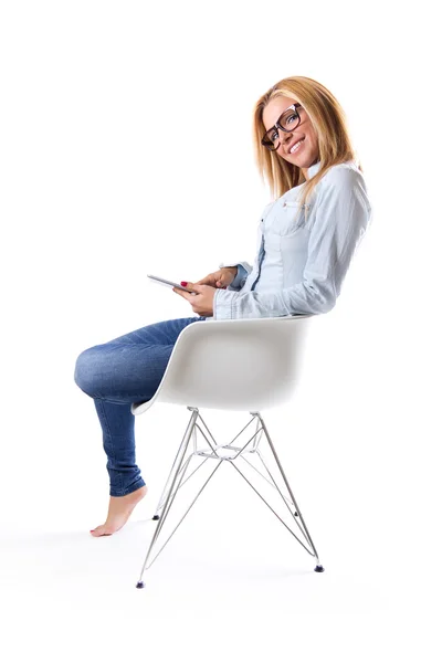 Hermosa joven sentada en casa con tableta digital — Foto de Stock