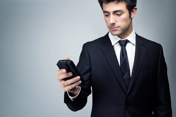 Young businessman looking at smartphone — Stock Photo, Image