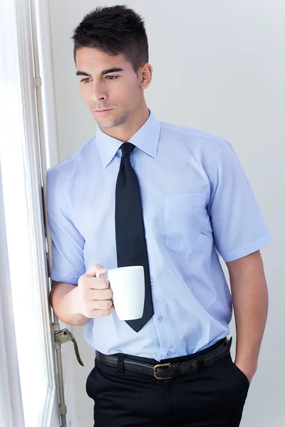Człowiek szczęśliwy młody biznes relaksujący z kubkiem kawy w nowoczesny poza — Stok fotoğraf