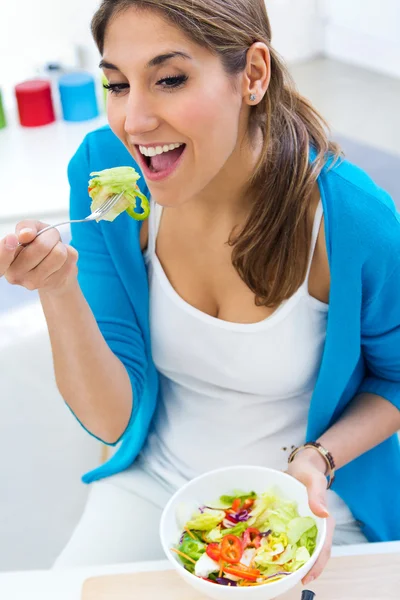 Bella giovane donna mangiare insalata a casa — Foto Stock