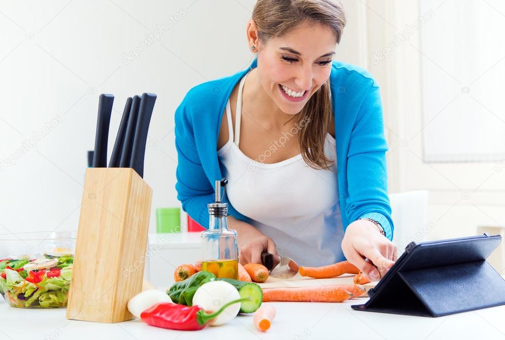 Pretty young woman cooking at home