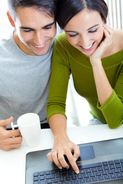 Heureux jeune couple naviguant sur Internet à la maison — Photo
