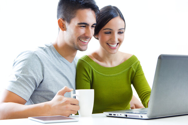 Happy young couple browsing internet at home