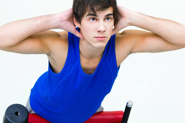 Jeune homme pratiquant le sport en salle de gym — Photo