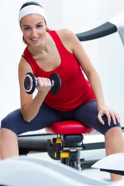 Joyeux jeune femme pratiquant le sport dans la salle de gym — Photo