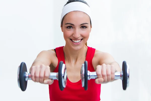 Joyeux jeune femme pratiquant le sport dans la salle de gym — Photo