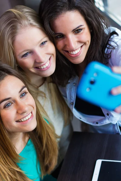 Tres amigos tomando fotos con un smartphone —  Fotos de Stock