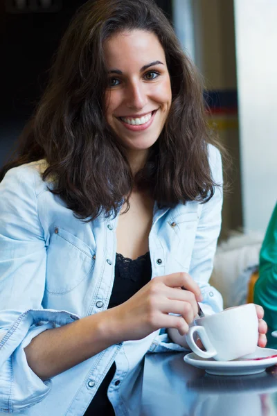 Mujer joven y bonita sentada en un café con una taza de café —  Fotos de Stock