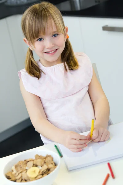 Детский рисунок карандашами, сидя за столом на кухне дома — стоковое фото