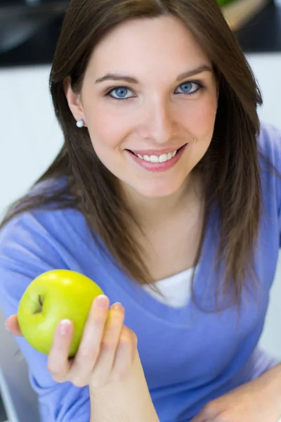 Młoda kobieta je zielone jabłko. — Zdjęcie stockowe