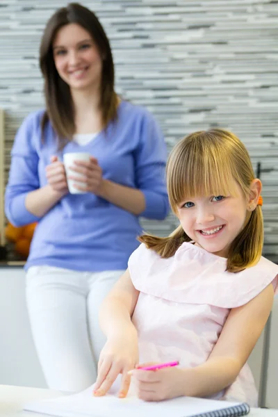 Child drawing with crayons with her mom at home — Stock Photo, Image