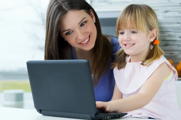 Mutter und Tochter benutzen Laptop in der Küche — Stockfoto