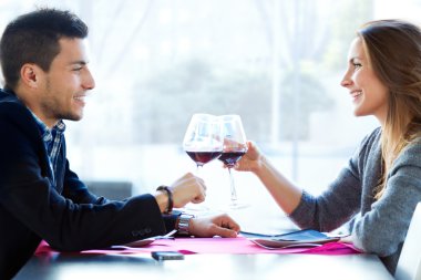 Genç çift restoranda şarap ile toasting sevgi dolu