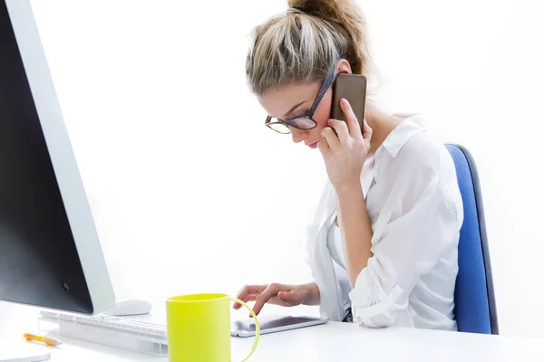 Young woman working from home on the computer and talking on the — Stock Photo, Image