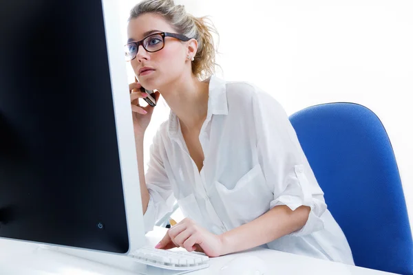 Jeune femme travaillant de la maison sur l'ordinateur et parlant sur le — Photo