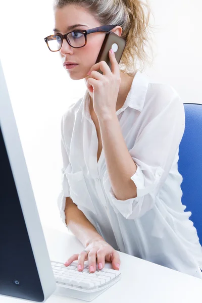 Young woman working from home on the computer and talking on the — Stock Photo, Image