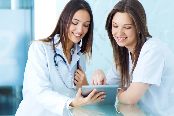 Medico e infermiere in cerca di qualcosa su un tablet digitale — Foto Stock