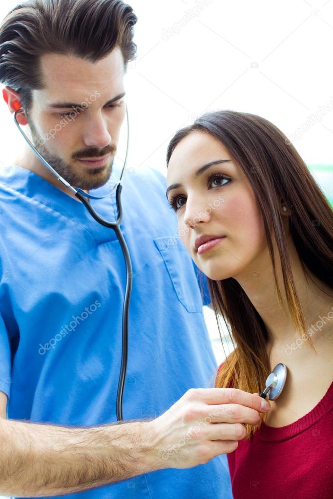 Doctor with stethoscope checking a patient Stock Photo by 40600159