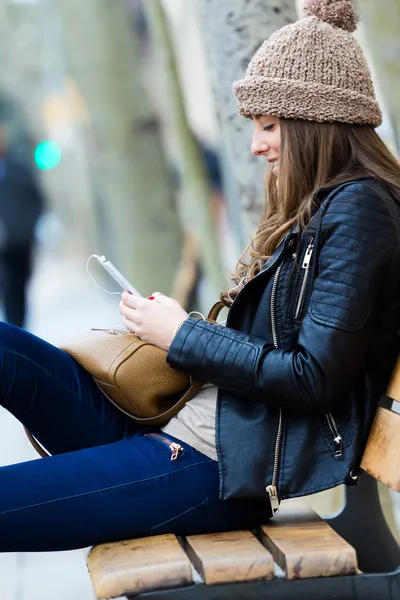 Młoda kobieta zakupy w mieście z jego telefonu komórkowego — Zdjęcie stockowe