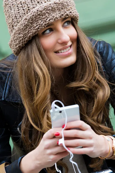 Junge Frau kauft mit Handy in der Stadt ein — Stockfoto