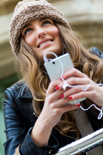 Jeune femme faisant du shopping en ville avec son téléphone portable — Photo
