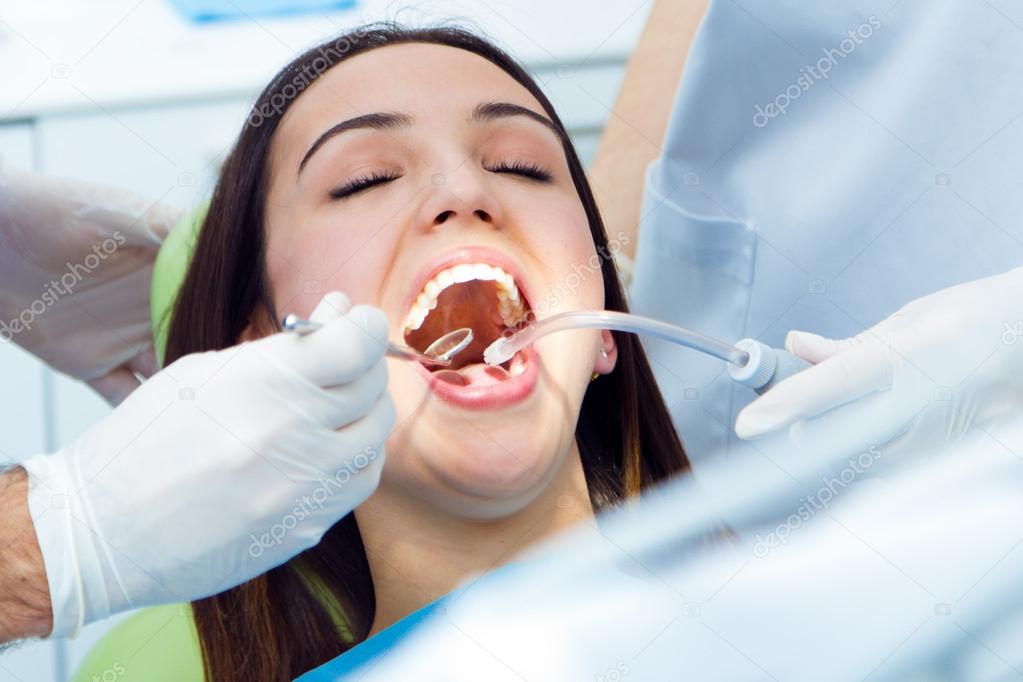Cute young woman at the dentist. Mouth checkup