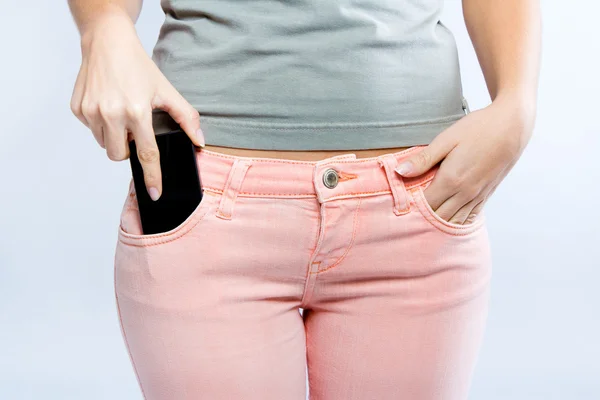 Schwarzes Smartphone in der Vordertasche der Jeans des Mädchens — Stockfoto