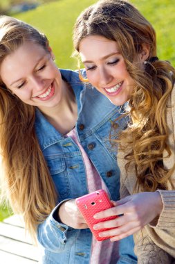 iki arkadaş akıllı telefonlar ile eğleniyor