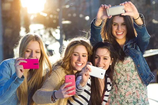 Um grupo de amigos tirando fotos com um smartphone — Fotografia de Stock