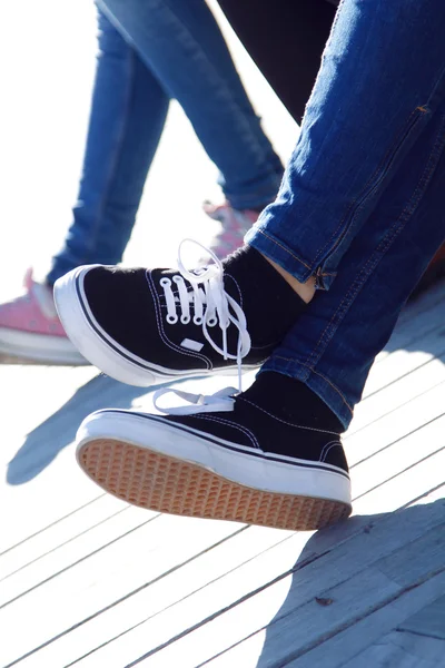 Legs of young girl in jeans and sneakers — Stock Photo, Image