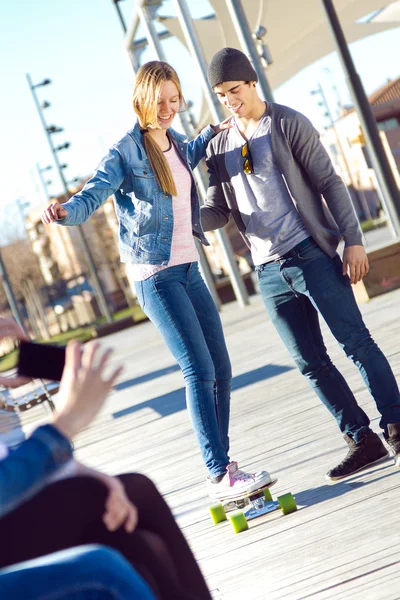 Dos amigos divirtiéndose con el patín — Foto de Stock