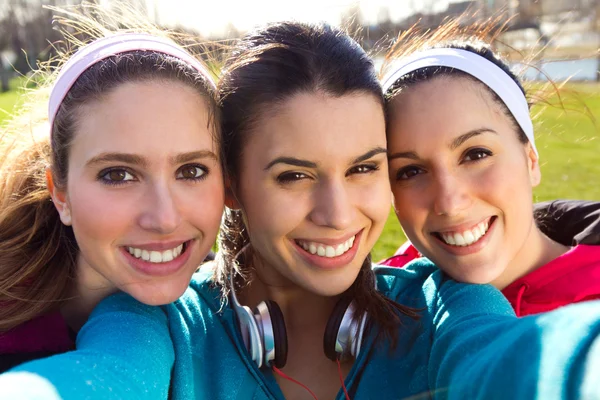 Tres amigos tomando fotos con un smartphone —  Fotos de Stock