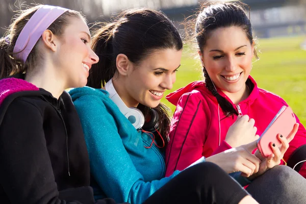 Friends having fun with smartphones after exercise — Stock Photo, Image