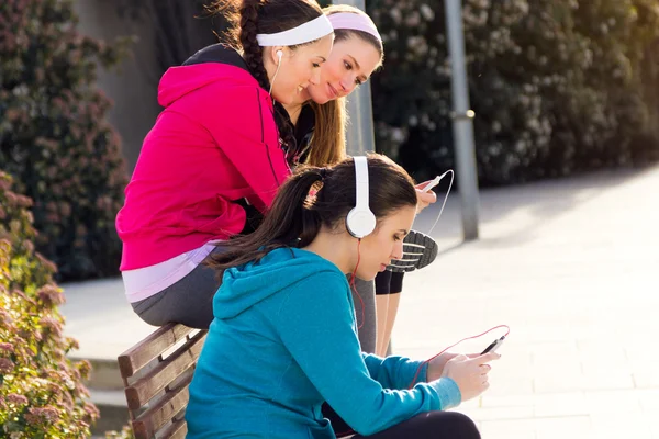 Amis s'amuser avec les smartphones après l'exercice — Photo