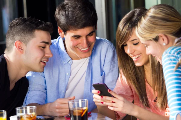 Amigos divirtiéndose con teléfonos inteligentes — Foto de Stock