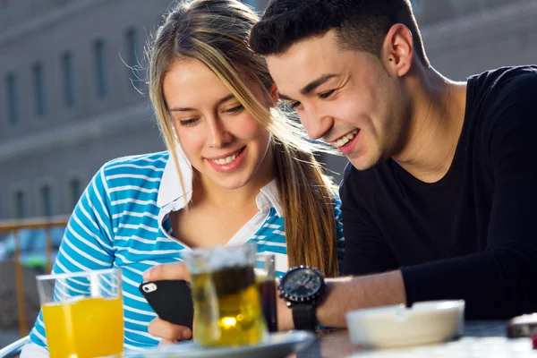 Young couple having fun with smartphones — Stock Photo, Image