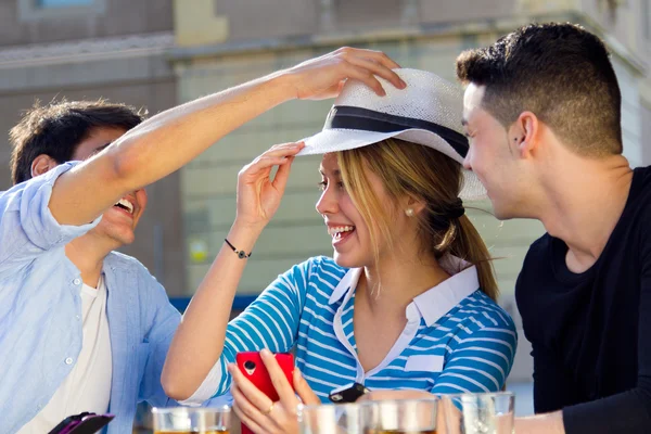 Friends having fun with with white hat in the street — Stock Photo, Image