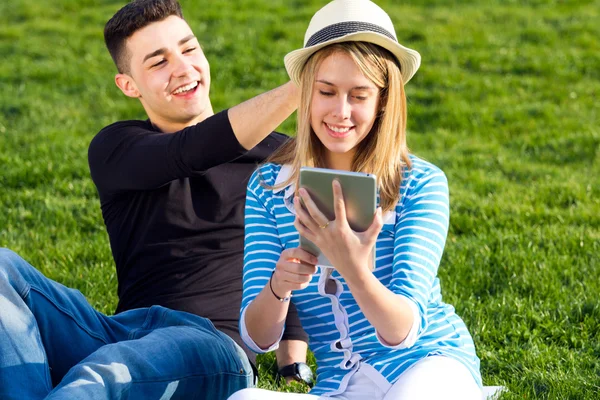 Jovem casal se divertindo com tablet digital — Fotografia de Stock