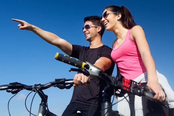 Feliz pareja joven en un paseo en bicicleta en el campo —  Fotos de Stock