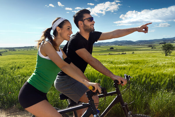 Happy young  couple on a bike ride in the countryside