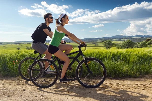 Happy young  couple on a bike ride in the countryside — Stock Photo, Image