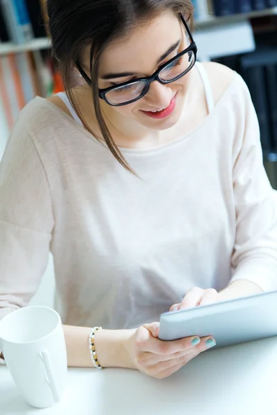 Mujer trabajadora joven con tableta digital en su oficina — Foto de Stock