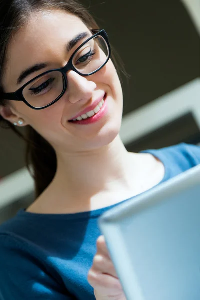 Mujer trabajadora joven con tableta digital en su oficina — Foto de Stock